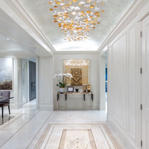 Gold and white circular glass pieces hanging from ceiling inside white interior home