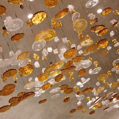 Close up on gold and white circular glass pieces hanging from ceiling